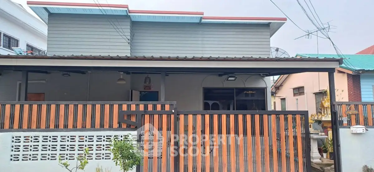 Charming single-story home with modern fence and rooftop extension in a quiet neighborhood.
