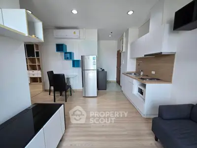 Modern open-layout kitchen and living area with sleek design and ample natural light.