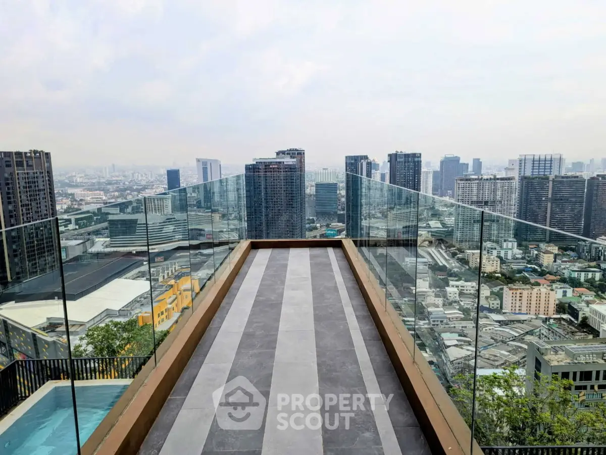 Stunning rooftop view with glass railings overlooking city skyline, perfect for urban living.