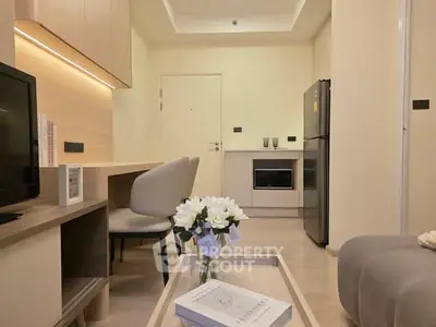 Modern living room with sleek furniture and integrated kitchen appliances.