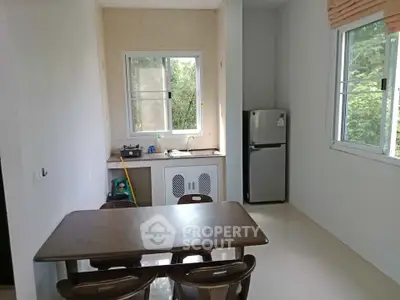 Cozy dining area with natural light and compact kitchen setup
