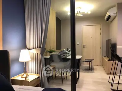 Modern studio apartment with stylish decor and cozy ambiance, featuring a compact dining area and sleek furnishings.