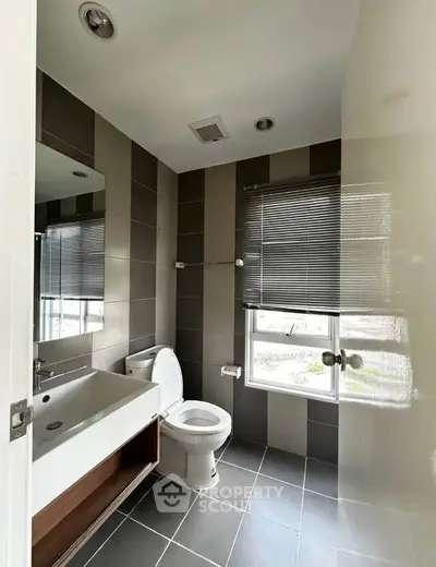 Modern bathroom with sleek fixtures and large window for natural light.