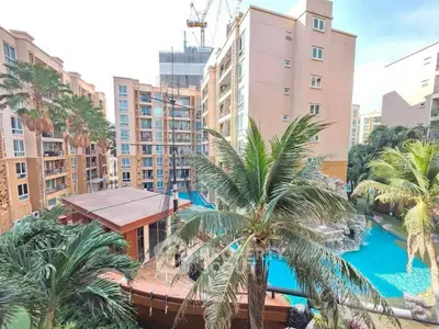 Luxurious apartment complex with pool and palm trees, perfect for resort-style living.