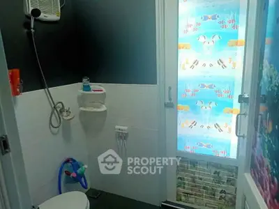 Charming bathroom with ocean-themed decor and modern shower amenities.