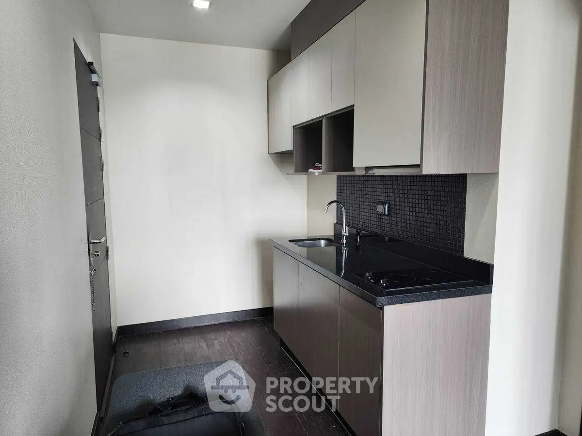 Modern compact kitchen with sleek cabinetry and black countertop