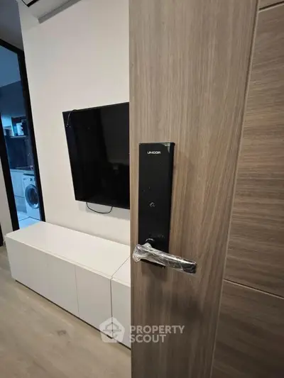 Modern living room with smart lock door and wall-mounted TV