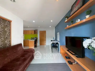 Modern living room with open kitchen, stylish decor, and cozy seating area.
