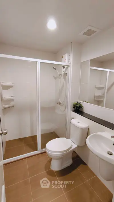 Modern bathroom with glass shower enclosure and sleek fixtures in a contemporary apartment.