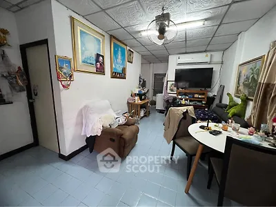 Cozy living room with eclectic decor and dining area, featuring comfortable seating and wall art.