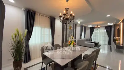 Luxurious open-plan living and dining area with elegant chandeliers and modern decor.