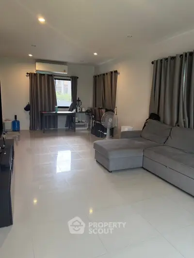 Spacious living room with modern gray sofa and large windows for natural light.