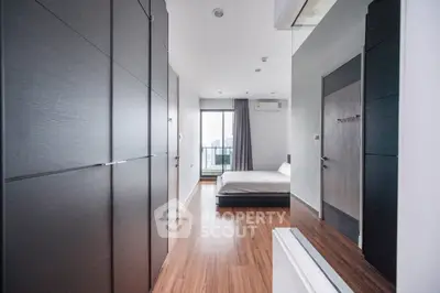 Modern bedroom with sleek design and city view balcony in luxury apartment.