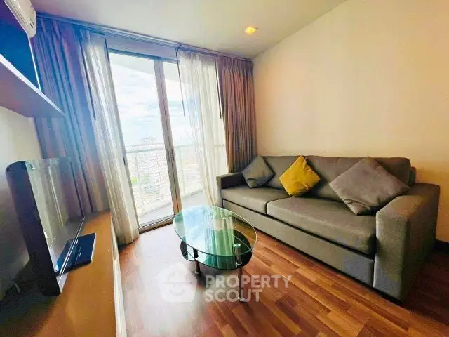 Modern living room with large window and stylish furniture in a high-rise apartment.