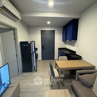 Modern apartment interior with compact kitchen and cozy living area, featuring sleek furniture and contemporary design.