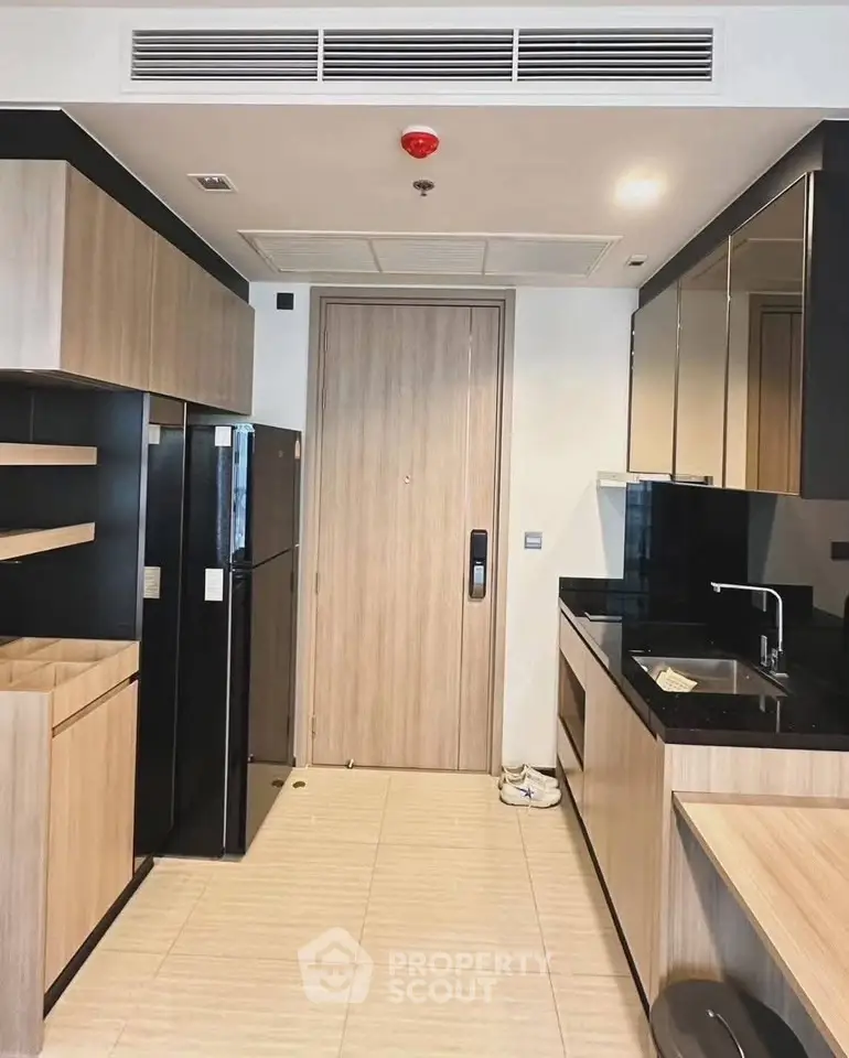 Modern kitchen with sleek cabinetry and black countertops in a stylish apartment.