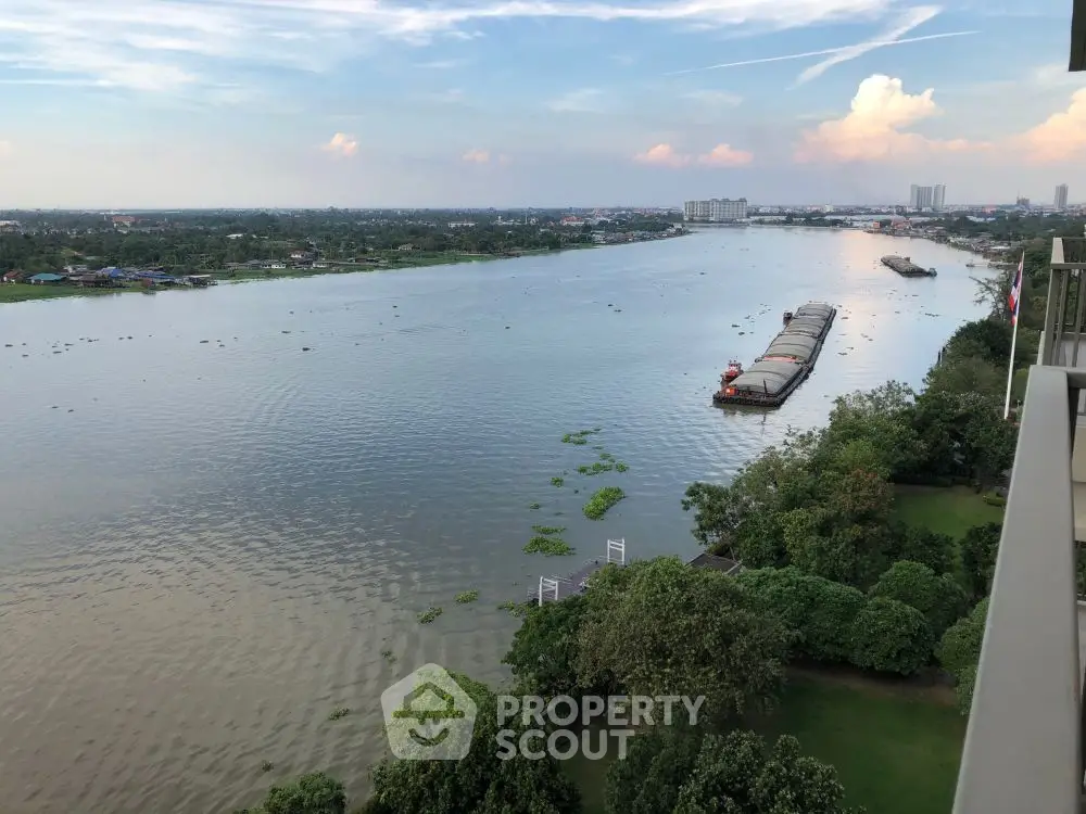 Stunning river view from high-rise balcony with lush greenery and serene waterway.