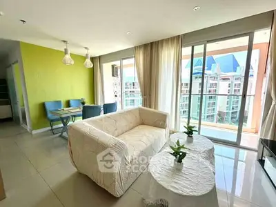 Spacious living room with modern decor and large balcony offering stunning city views.