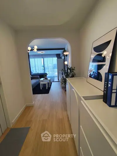 Stylish hallway leading to a modern living room with elegant decor and natural light.