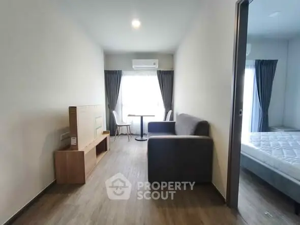 Modern apartment interior with cozy living room and bedroom, featuring sleek furniture and natural light.