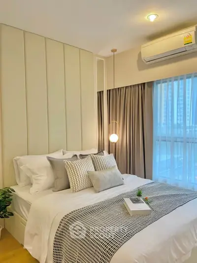 Modern bedroom with stylish decor and natural light, featuring cozy bedding and elegant lighting.