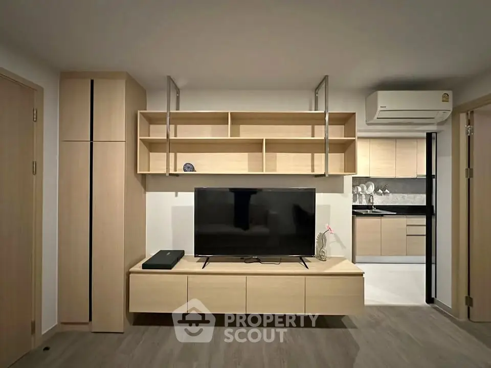 Modern living room with sleek wooden furniture and open kitchen layout