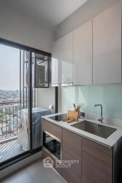 Modern kitchen with balcony view and sleek appliances