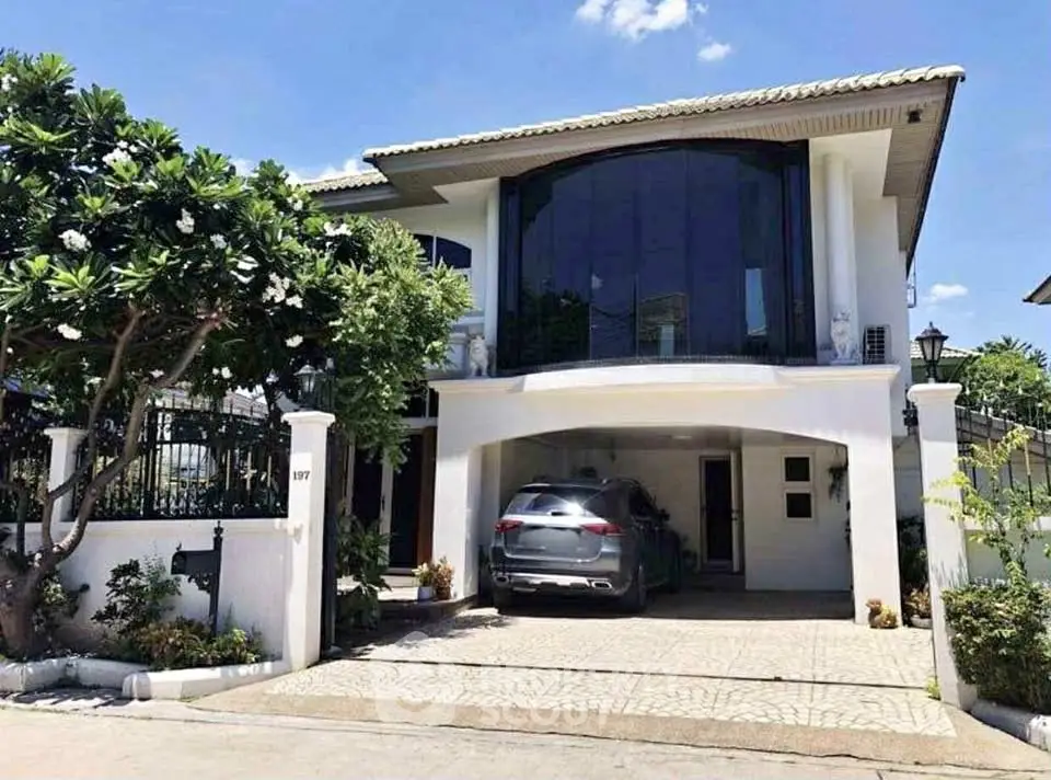 Stunning modern two-story house with spacious driveway and lush greenery.