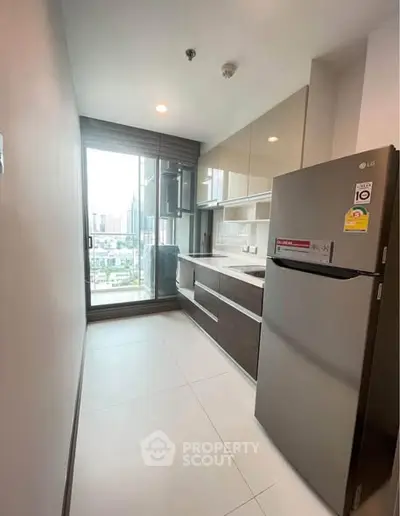 Modern kitchen with sleek cabinets and city view from window.