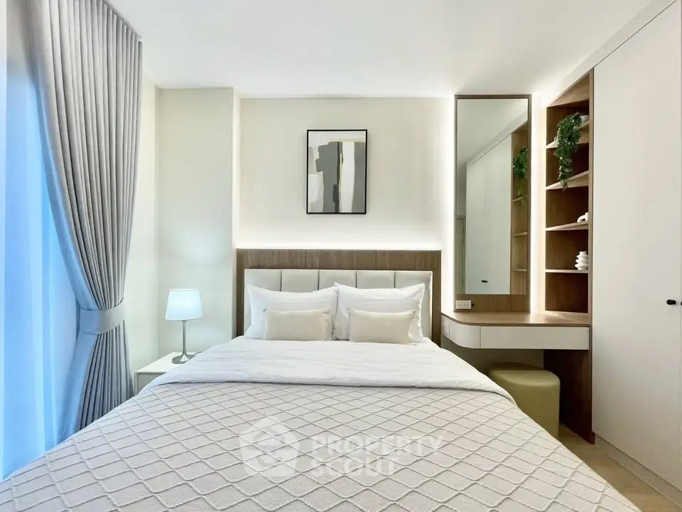 Modern bedroom with elegant decor, featuring a cozy bed, stylish lamp, and built-in shelving for a luxurious feel.
