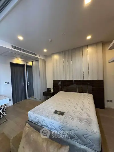 Modern bedroom with stylish decor and ample storage in a luxury apartment.