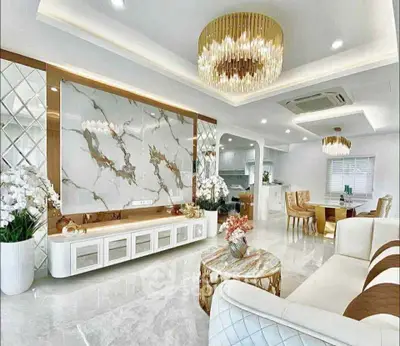 Luxurious living room with elegant decor and open layout, featuring marble accents and modern lighting.
