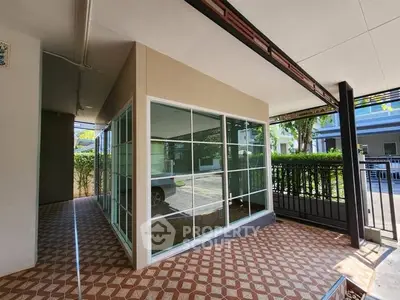 Spacious covered patio with large windows and patterned tile flooring
