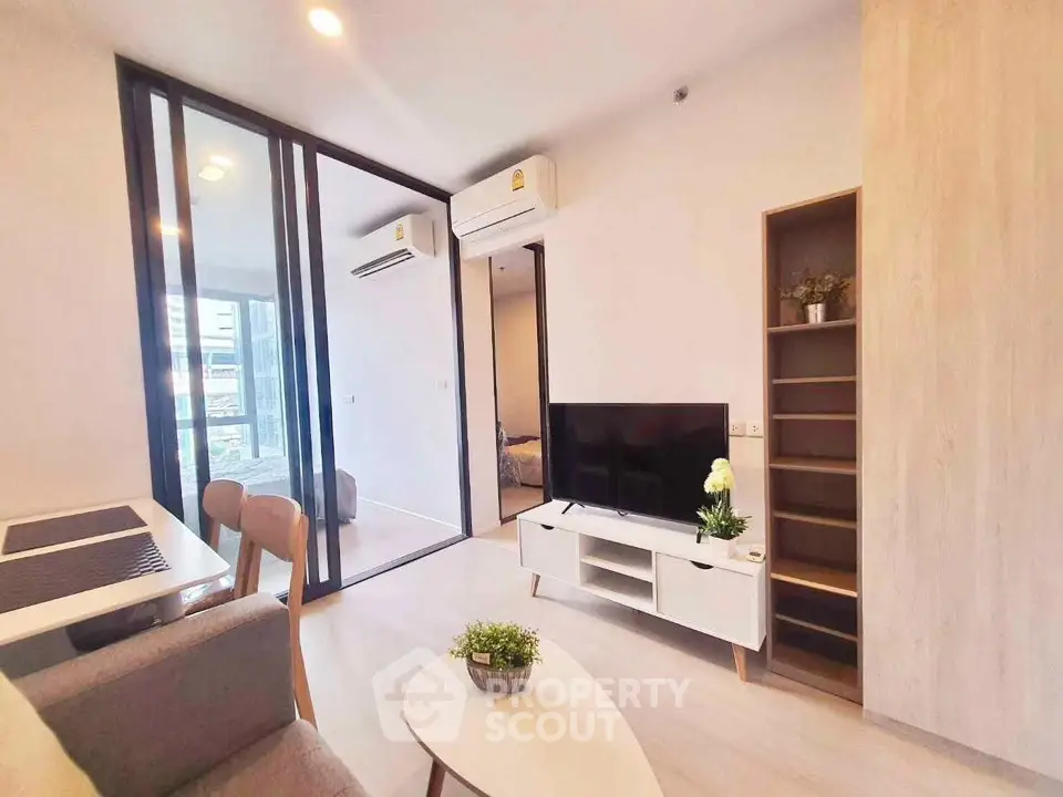 Modern living room with sleek furniture and glass partition in a stylish apartment.