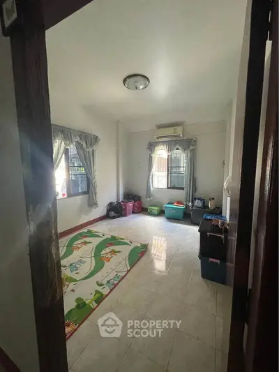 Spacious bedroom with tiled floor and natural light, ideal for family living.