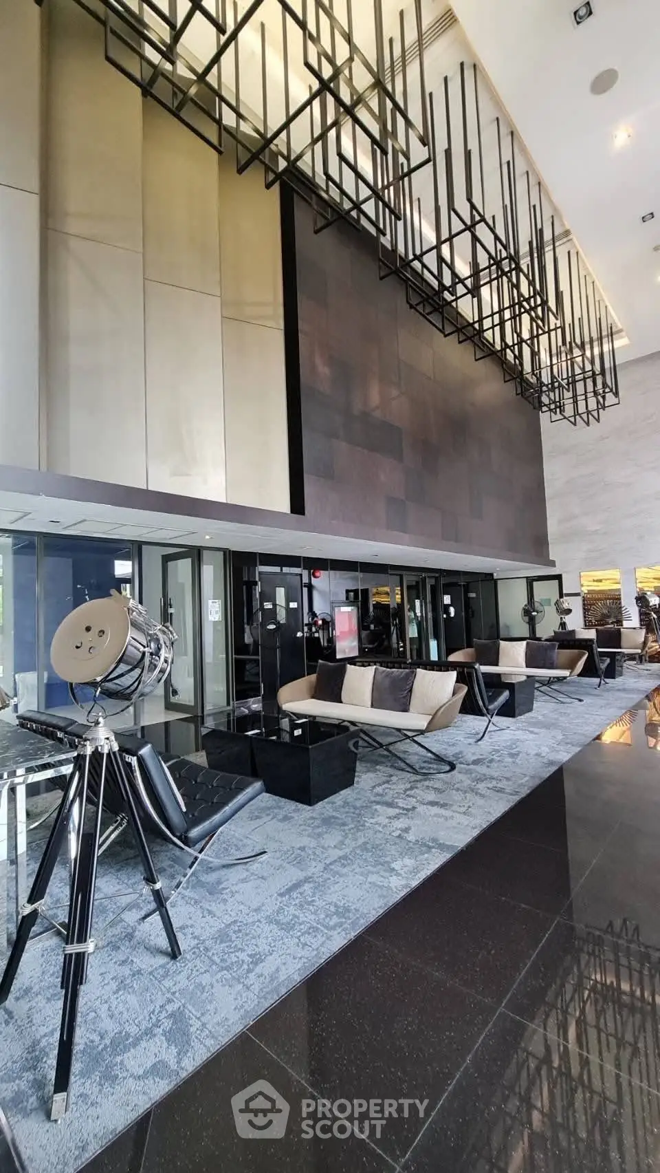 Luxurious modern building entrance with stylish seating and unique lighting fixtures.