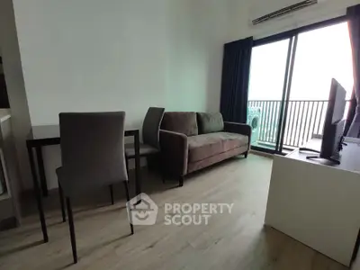 Modern living room with balcony view, sleek furniture, and natural light.