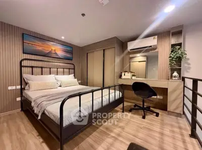 Modern bedroom with stylish decor and workspace, featuring a cozy bed and air conditioning.