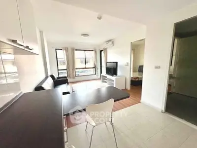 Modern open-plan living room with sleek furniture and natural light, perfect for urban living.