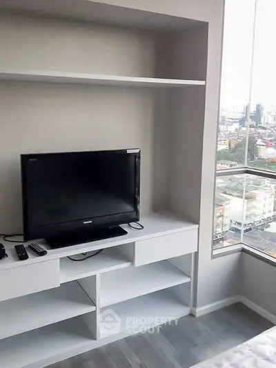 Modern living room with built-in TV unit and city view from large window