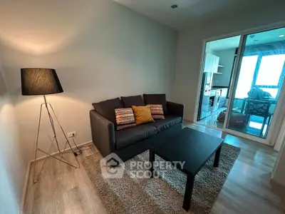Cozy living room with modern decor and adjacent kitchen area in a stylish apartment.