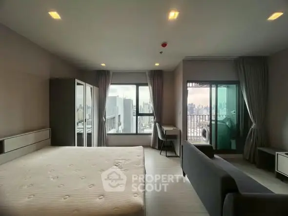 Spacious modern bedroom with city view and balcony access