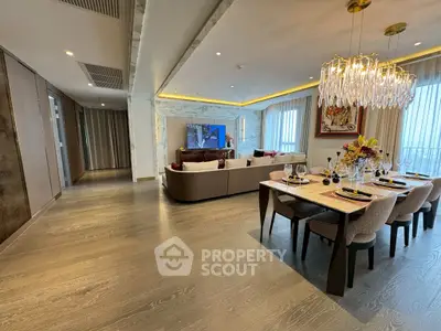 Luxurious open-plan living and dining area with elegant chandelier and modern decor.