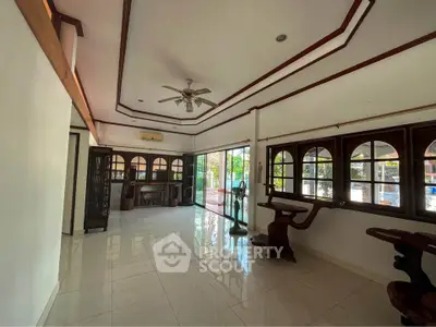Spacious living room with large windows and elegant wooden accents