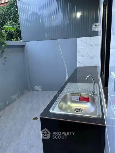 Outdoor kitchen area with stainless steel sink and modern design