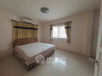 Spacious bedroom with natural light and elegant curtains