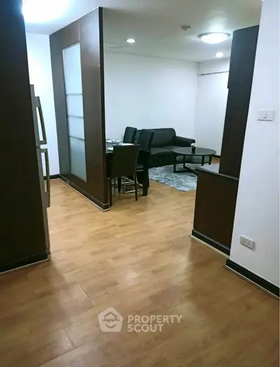 Spacious living room with modern furniture and wooden flooring in a stylish apartment.