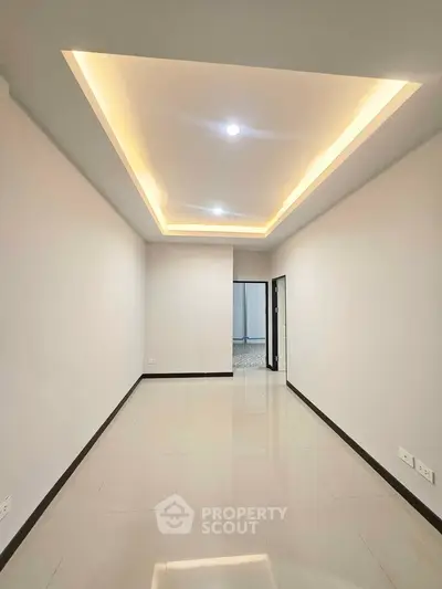 Spacious modern room with recessed lighting and glossy tiled floor
