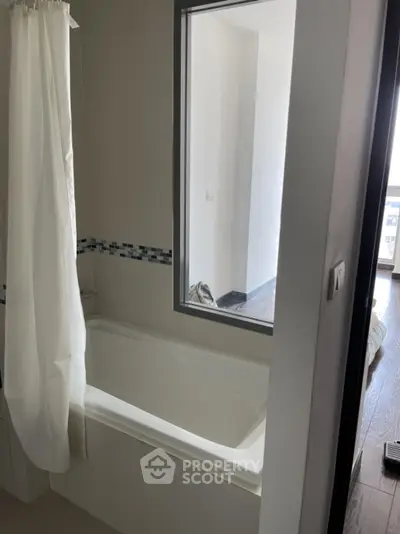 Modern bathroom with bathtub and window view in contemporary apartment