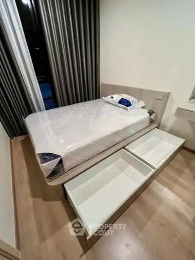 Modern bedroom with storage bed and stylish curtains, perfect for maximizing space in urban living.
